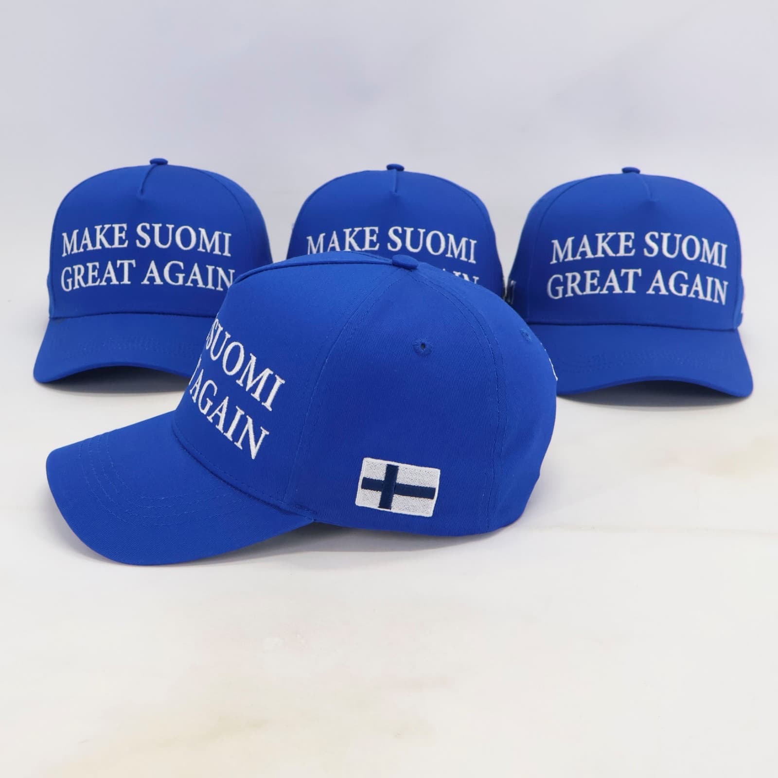 Sininen lippis oikealta, brodeerattu Suomen lippu