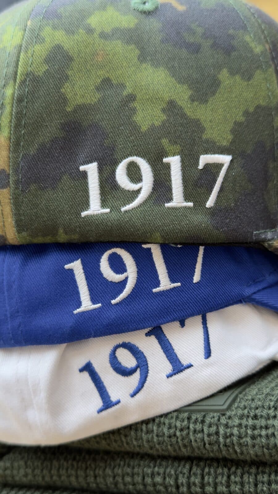 Kolme MSGA-lippistä päällekkäin, maasto, sininen ja valkoinen, sivussa brodeerattu vuosiluku 1917